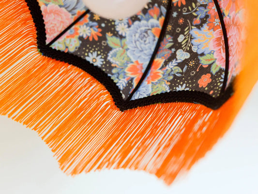 vue d'un abat jour original forme dôme avec des franges oranges.