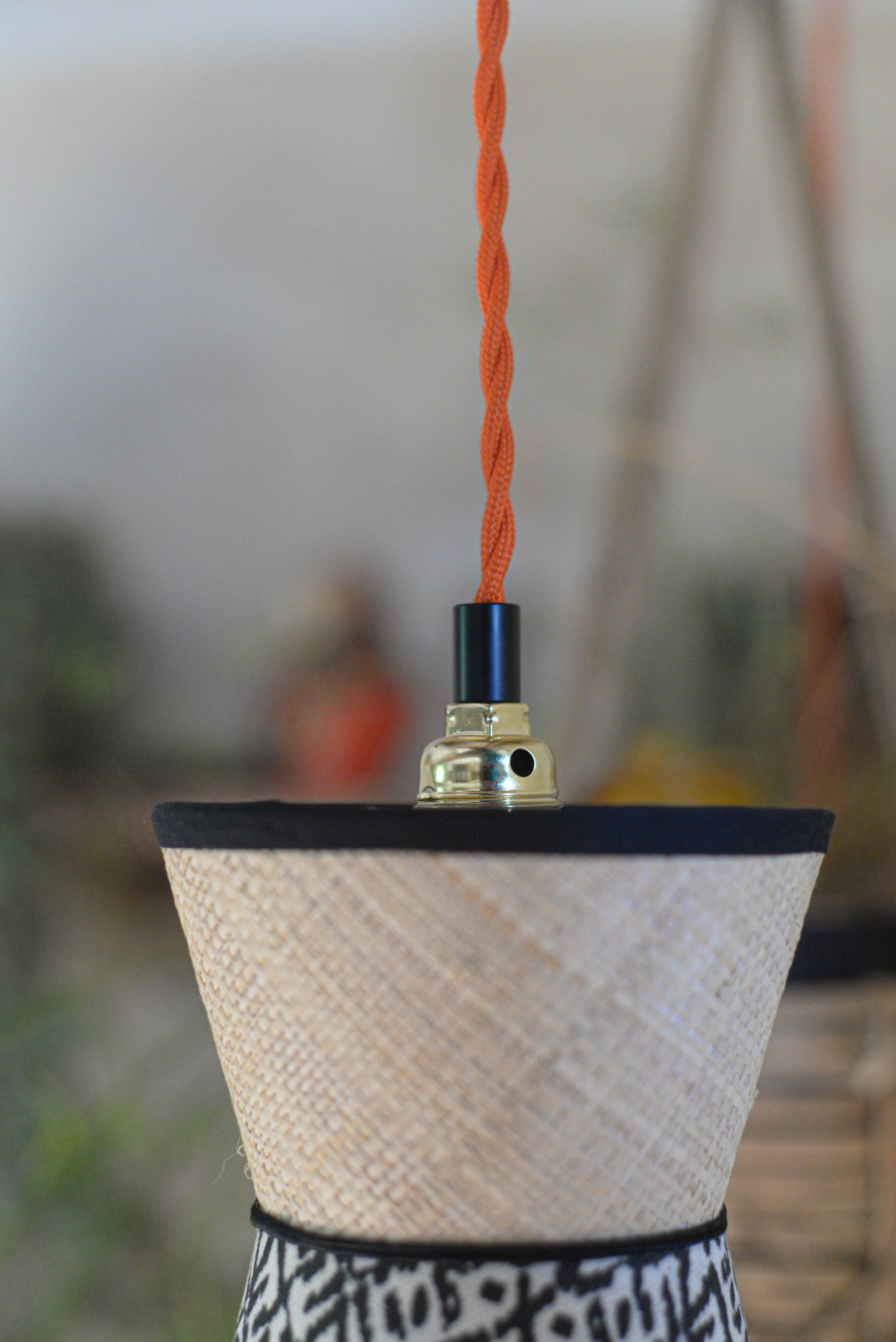 Vue du cordon torsadé d'une suspension baladeuse diabolo double cone en raphia et tissu ethnique