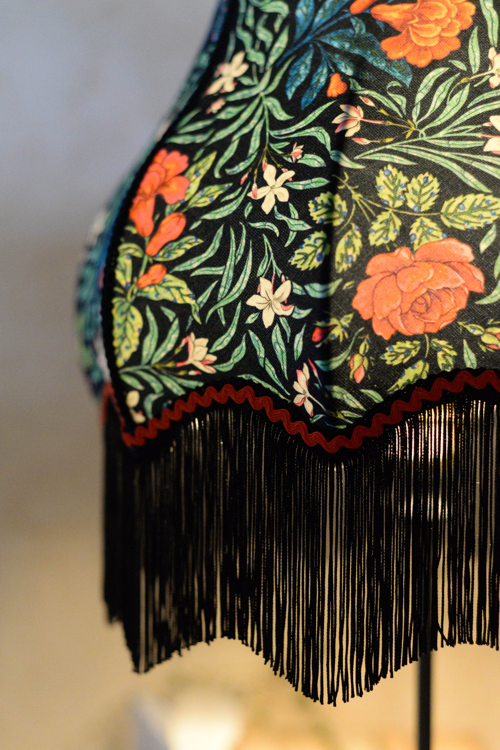 Profil d'un abat-jour vintage pour pied de lampe réalisé en tissu odile bailloeul coloré et fleuri avec des franges. Création d'une abat-jouriste située près de rennes en Bretagne