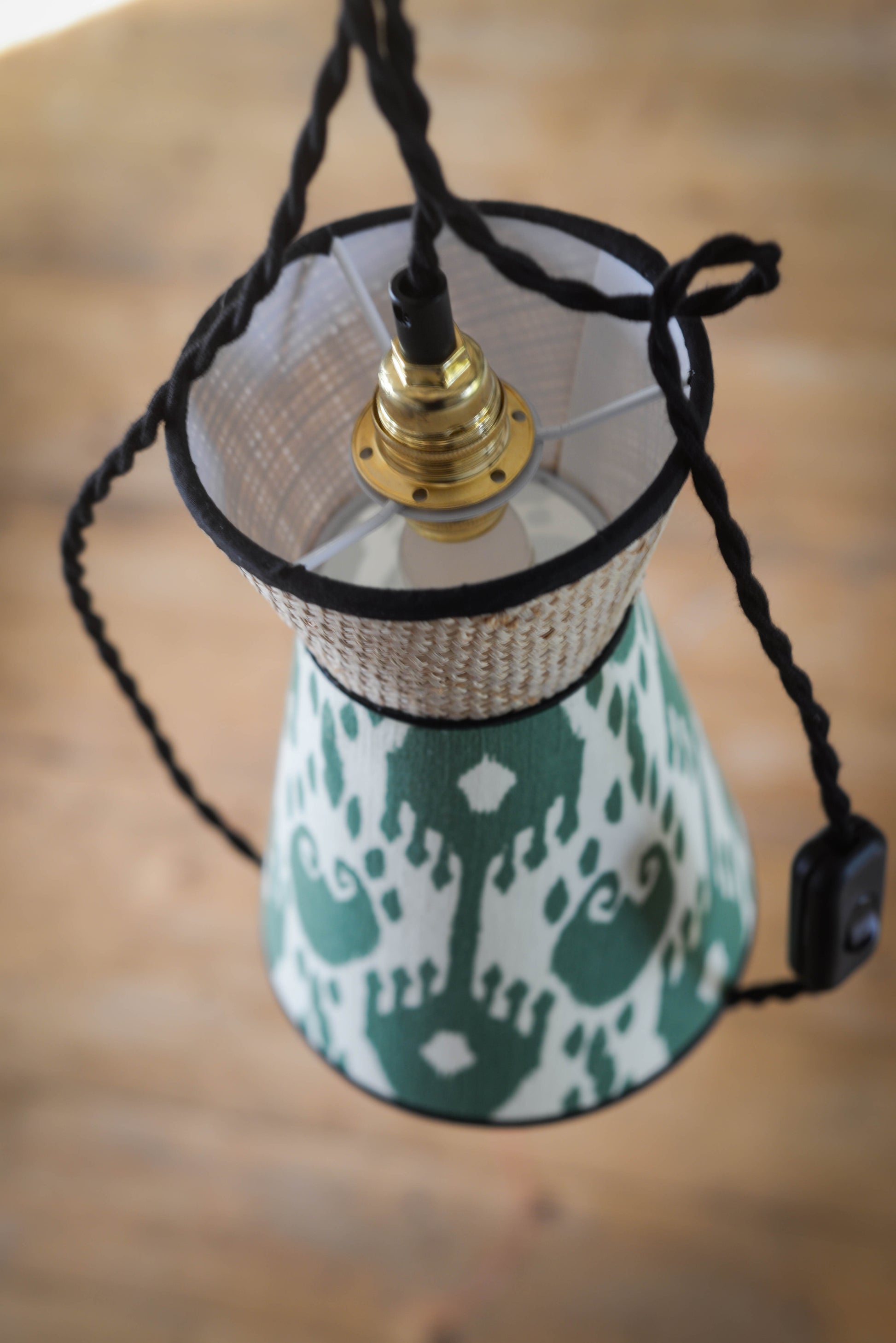 un luminaire baladeuse de forme vintage en rotin tressé et tissu ikat fabriqué par une abat-jouriste en bretagne près de rennes. Abat-jour unique, original et sur mesure