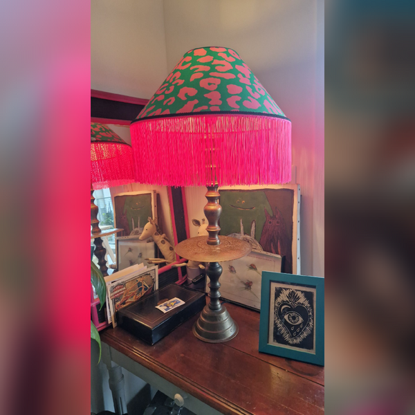 abat jour artisanal sur mesure réalisé pour une cliente. Forme conique avec un tissu léopard rose et vert et franges roses. Décoration vintage