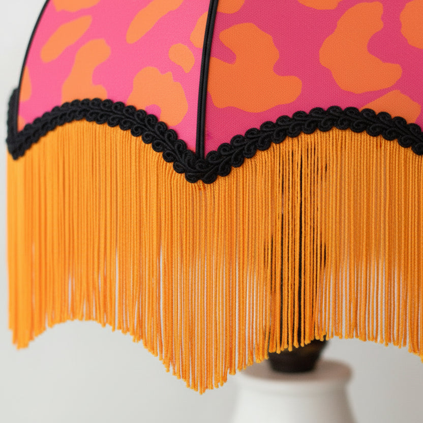 photo proche d'un abat-jour dome vintage tissu léopard rose orange et frange orange