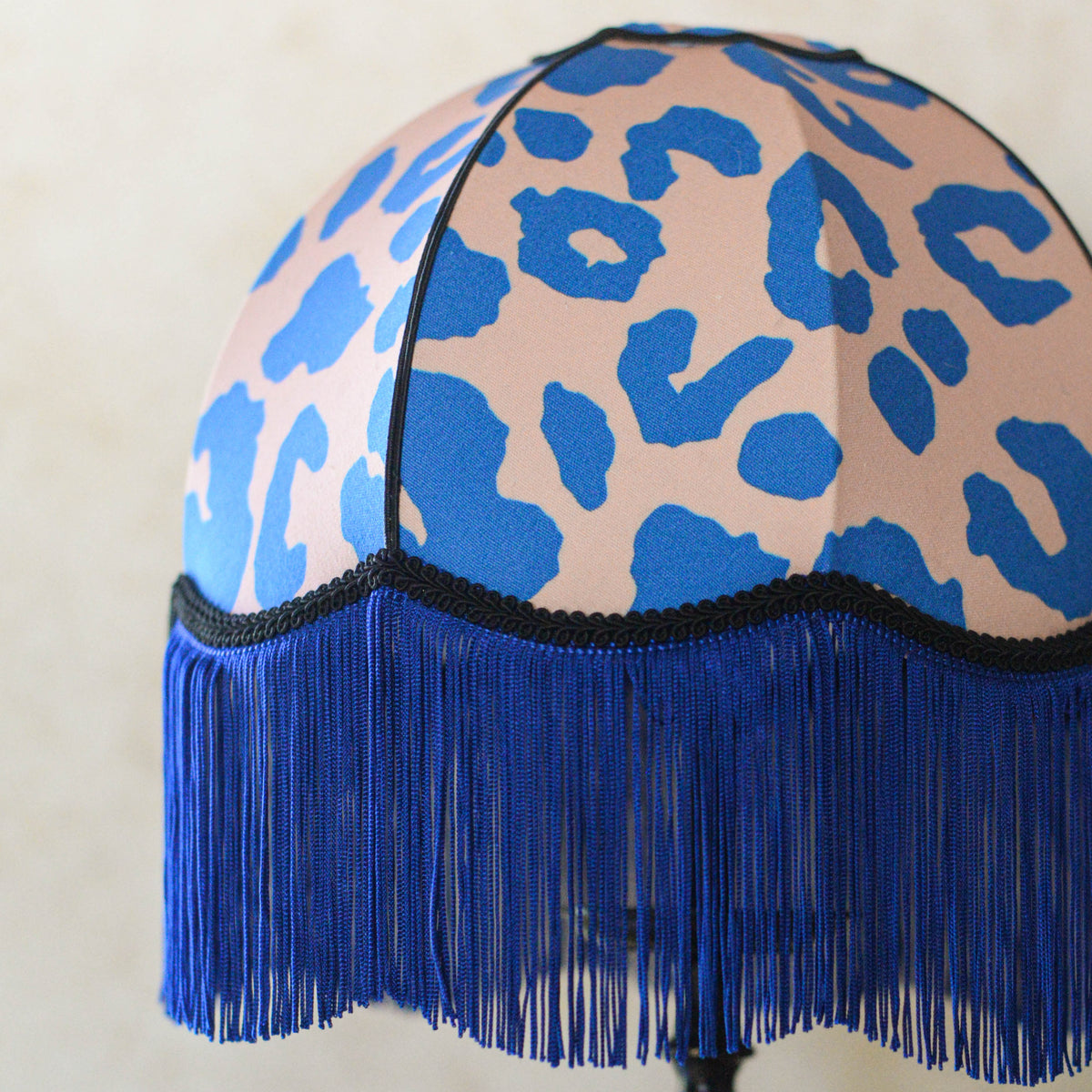 abat-jour en forme de dôme en tissu léopard rose et bleu et franges bleues. Fabrication artisanale par une abat-jouriste en Bretagne