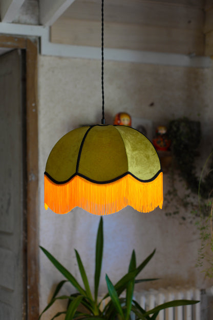 Un abat jour en suspension dome velours kaki et franges oranges. Ambiance bohème vintage