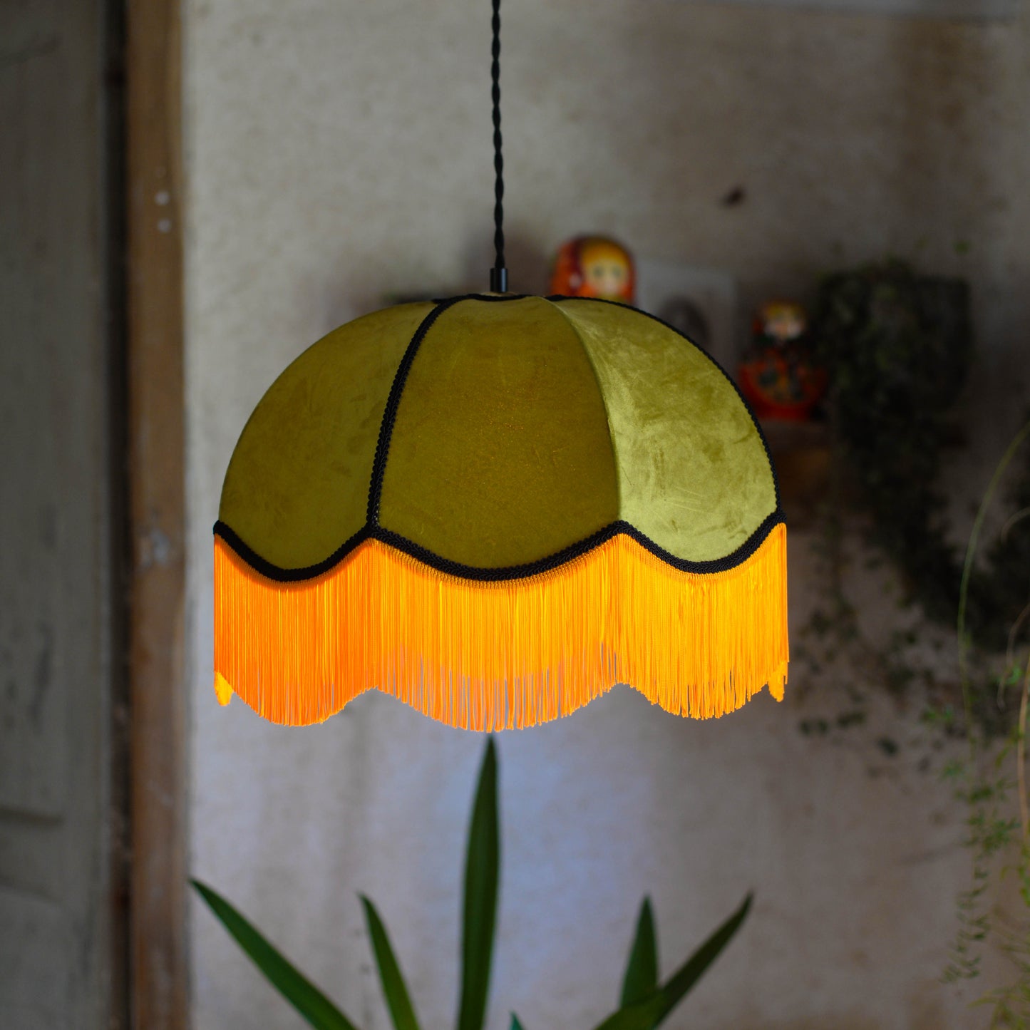 Un abat jour en suspension dome velours kaki et franges oranges. Ambiance bohème vintage