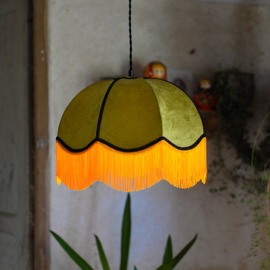Un abat jour en suspension dome velours kaki et franges oranges. Ambiance bohème vintage