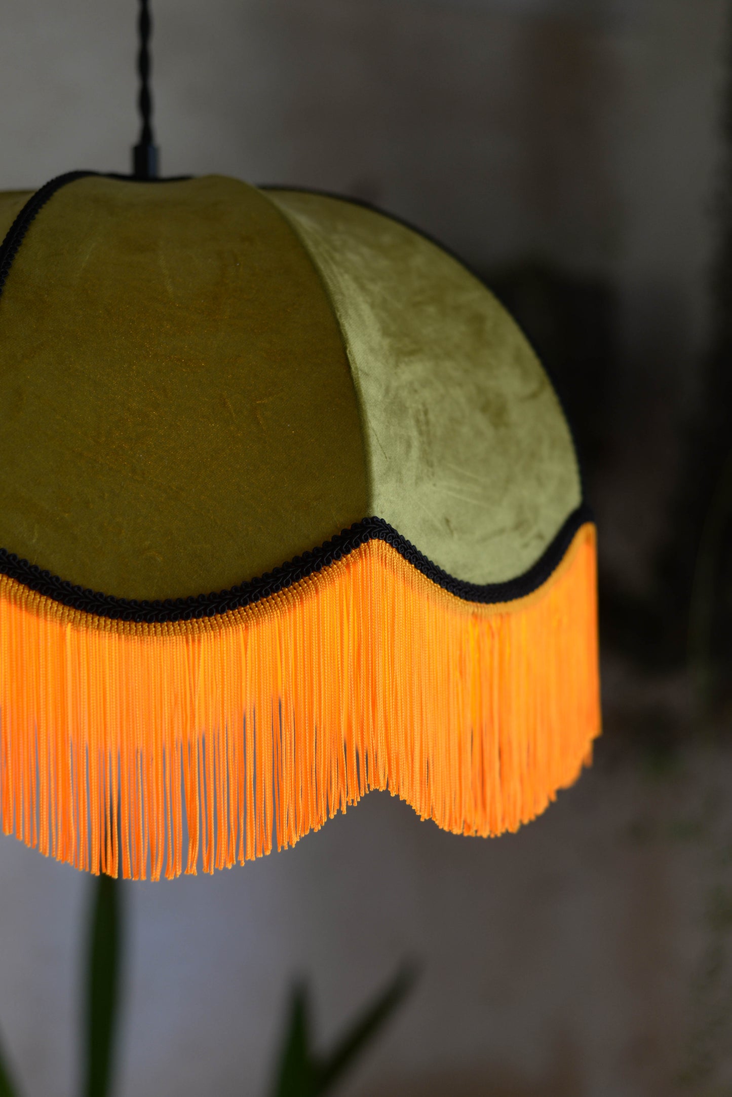 Un abat jour en suspension dome velours kaki et franges oranges. Ambiance bohème vintage