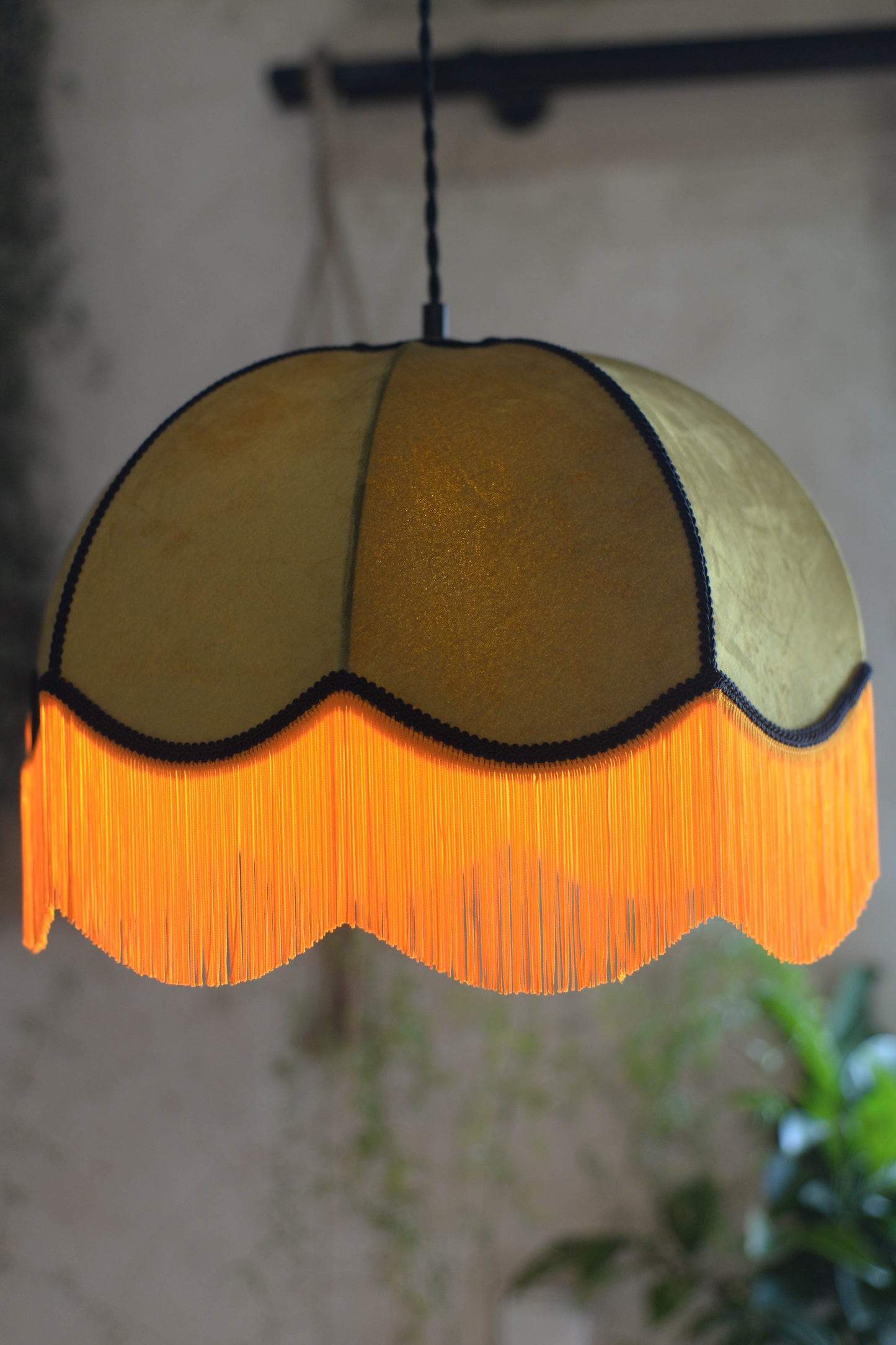 Un abat jour en suspension dome velours kaki et franges oranges. Ambiance bohème vintage