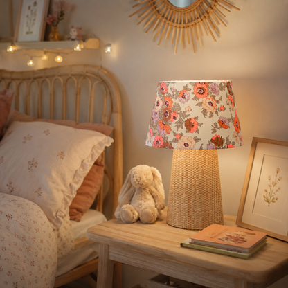 lampe à poser en raphia et abat jour fleuri dans une chambre d'enfant