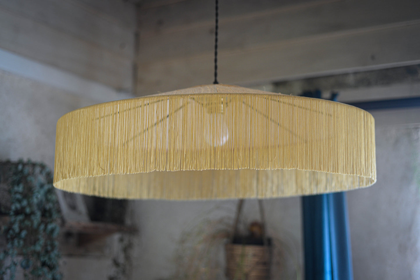 un luminaire suspension XL en raphia naturel tissé et franges beige. Réalisation unique et sur mesure réalisé par une abat-jouriste en Bretagne.