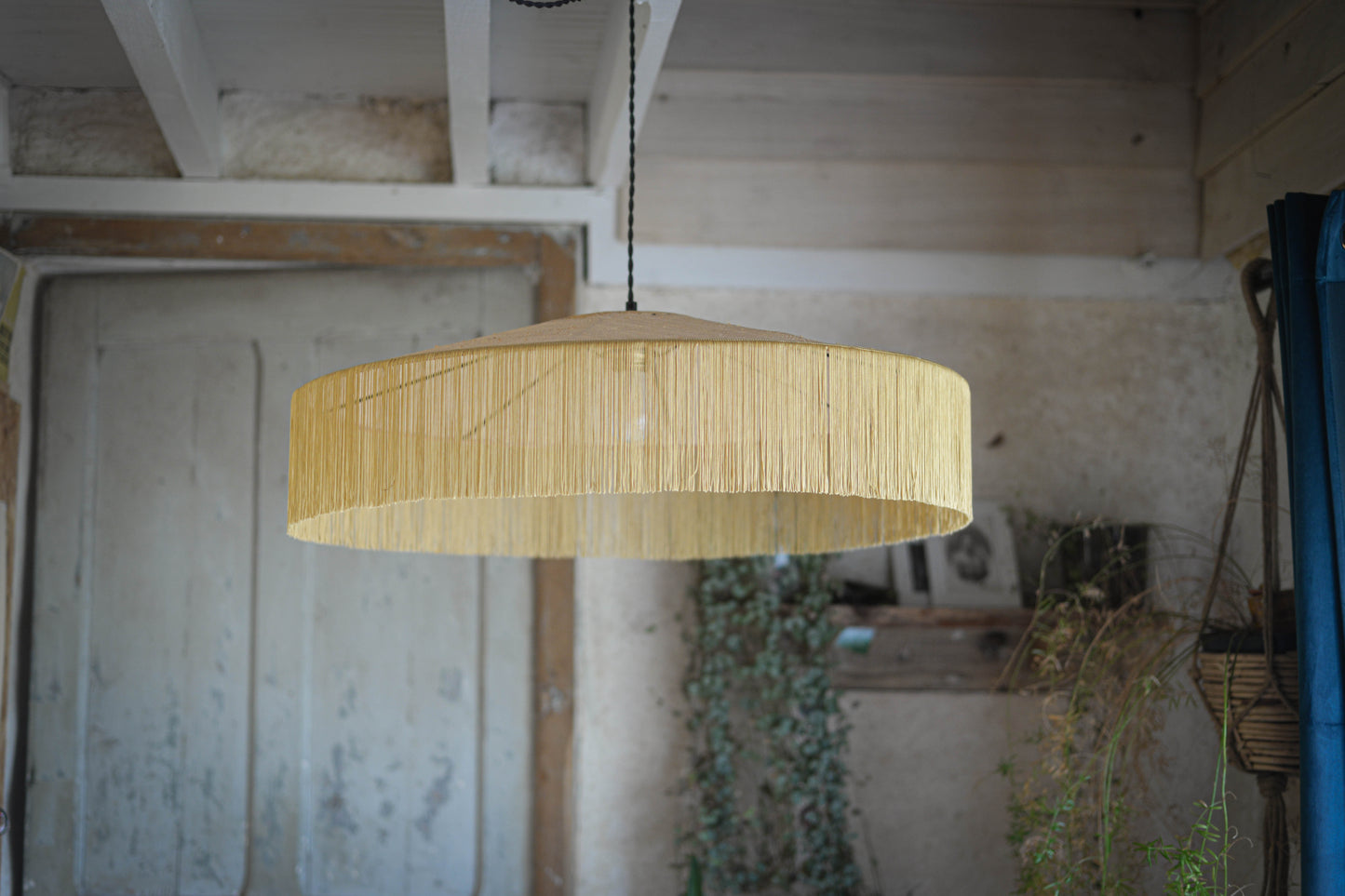 un luminaire suspension XL en raphia naturel tissé et franges beige. Réalisation unique et sur mesure réalisé par une abat-jouriste en Bretagne.