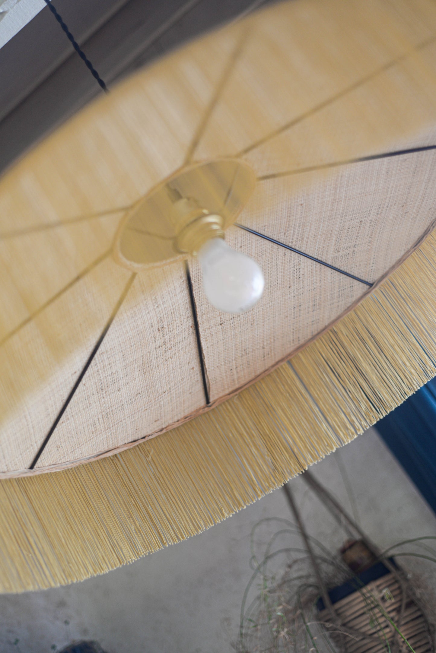 un luminaire suspension XL en raphia naturel tissé et franges beige. Réalisation unique et sur mesure réalisé par une abat-jouriste en Bretagne.