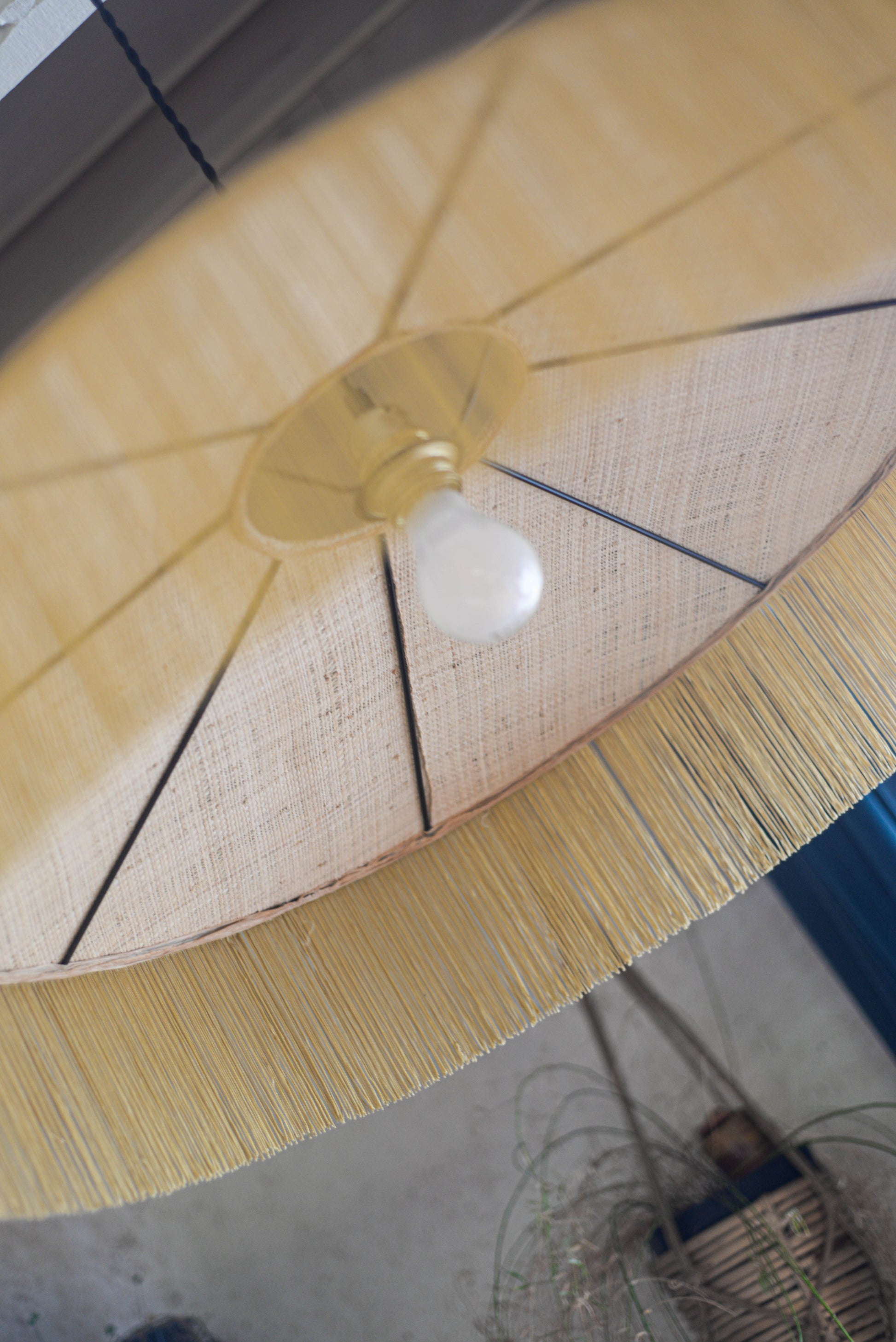 un luminaire suspension XL en raphia naturel tissé et franges beige. Réalisation unique et sur mesure réalisé par une abat-jouriste en Bretagne.