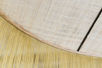 un luminaire suspension XL en raphia naturel tissé et franges beige. Réalisation unique et sur mesure réalisé par une abat-jouriste en Bretagne.