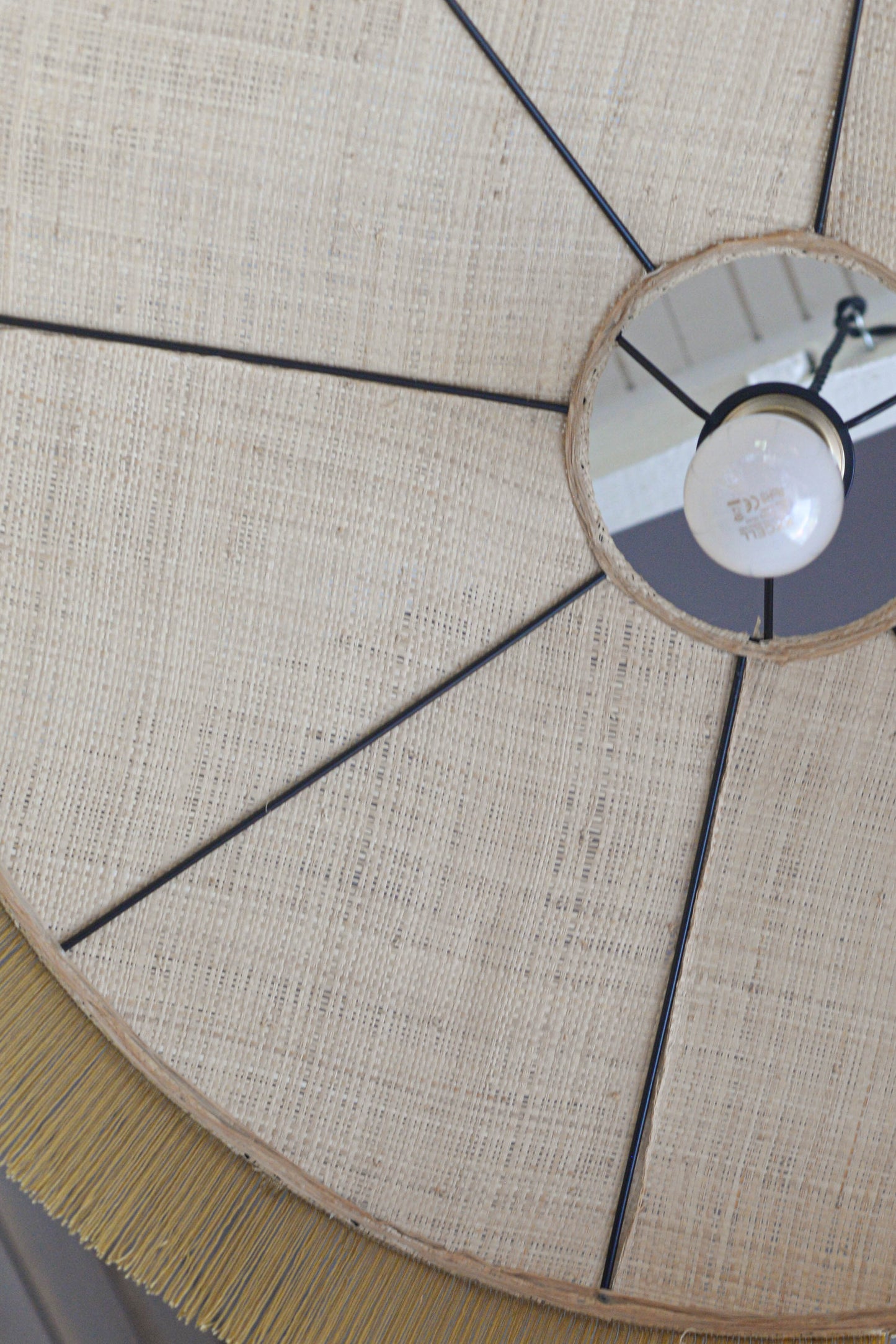 un luminaire suspension XL en raphia naturel tissé et franges beige. Réalisation unique et sur mesure réalisé par une abat-jouriste en Bretagne.