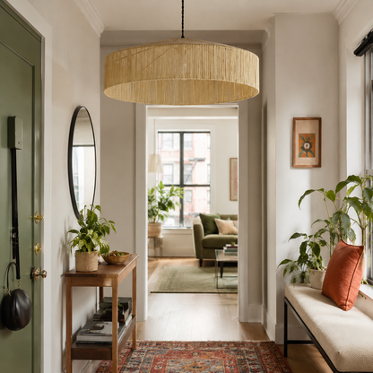 suspension artisanale XL en raphia et franges beiges dans une entree d'appartement. Luminaire fait main sur mesure